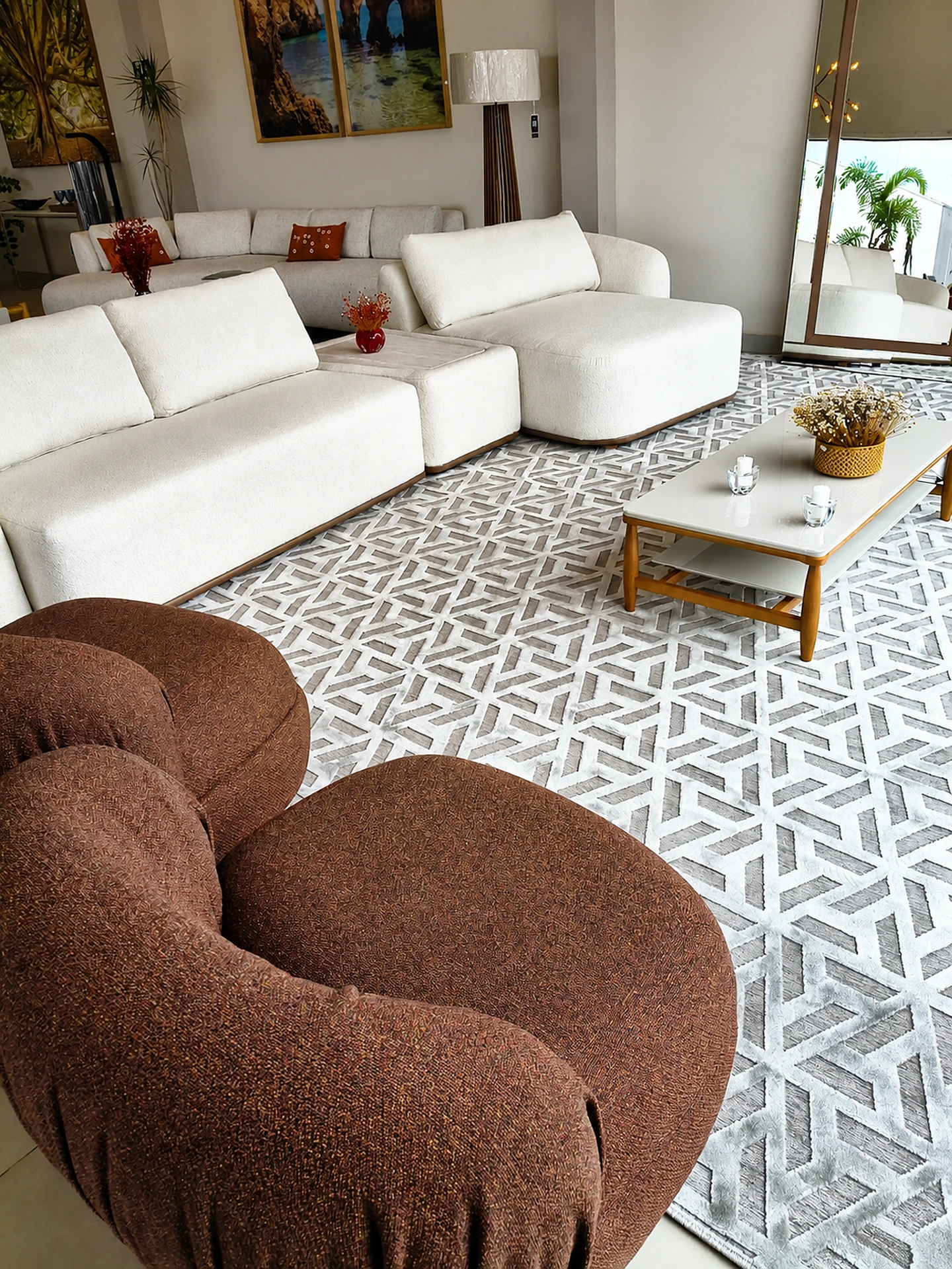Sala da Sintonia com sofá claro e poltrona de formas orgânicas